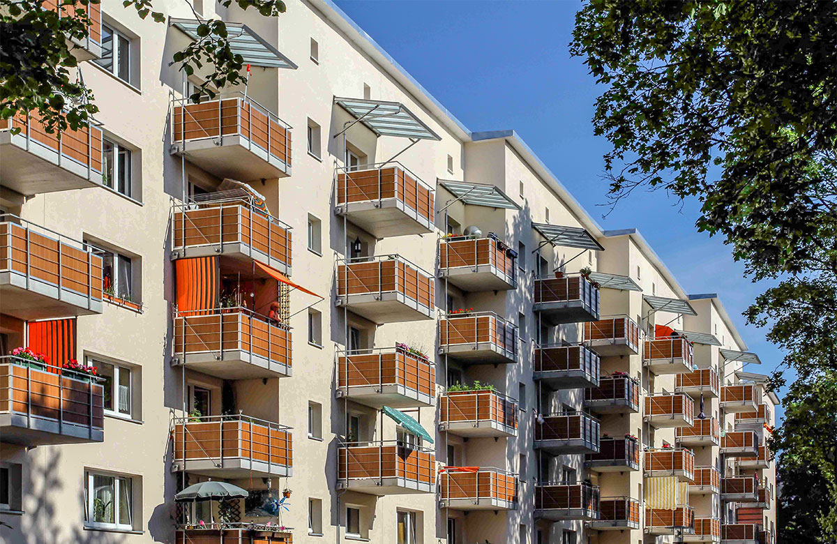 Abgehängte Betonbalkone mit Stahl-Trespa-Geländer in Holzoptik